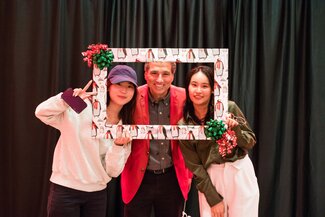 Three people looking through a picture frame